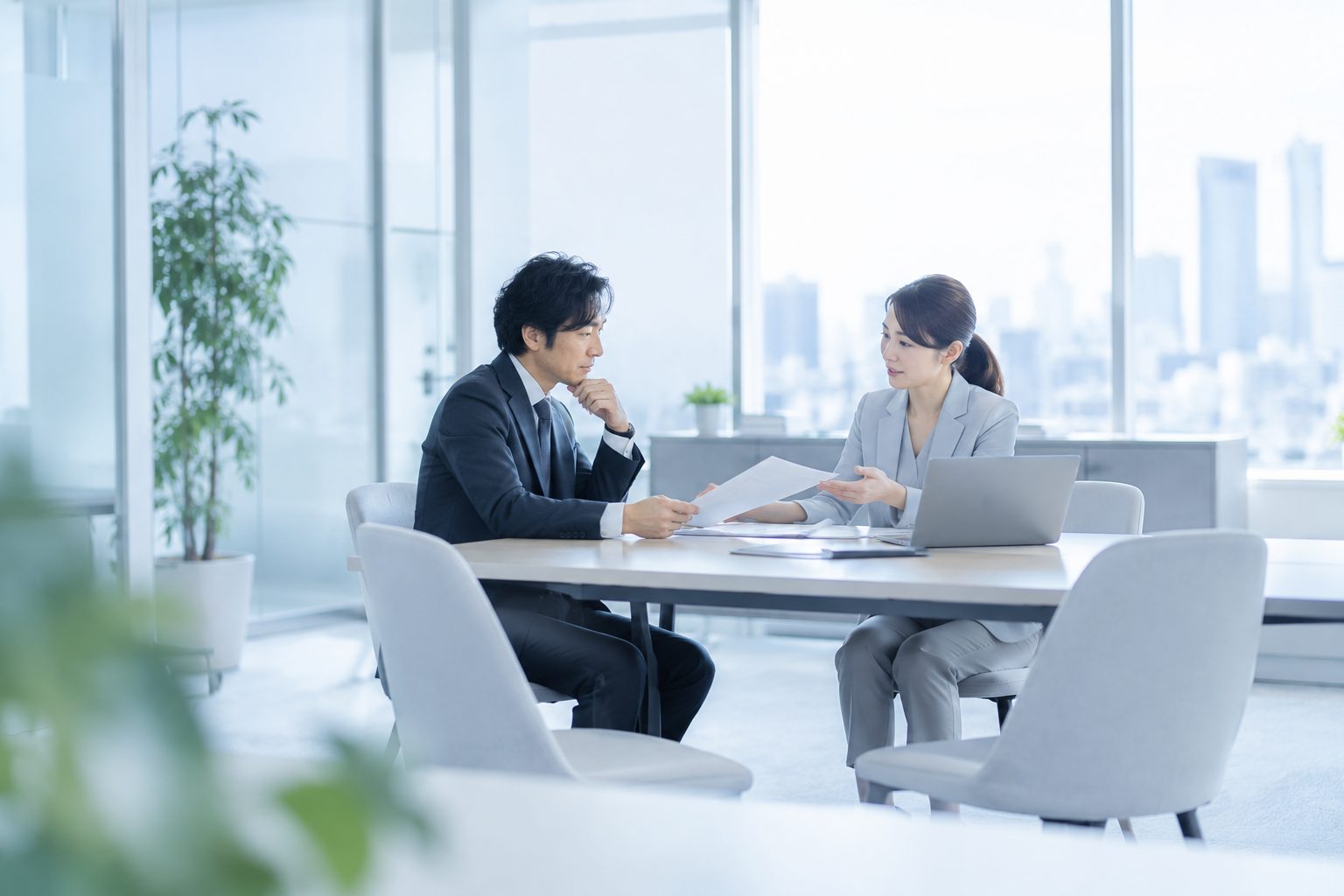 オフィスで経営者と税理士が打ち合わせをしている様子